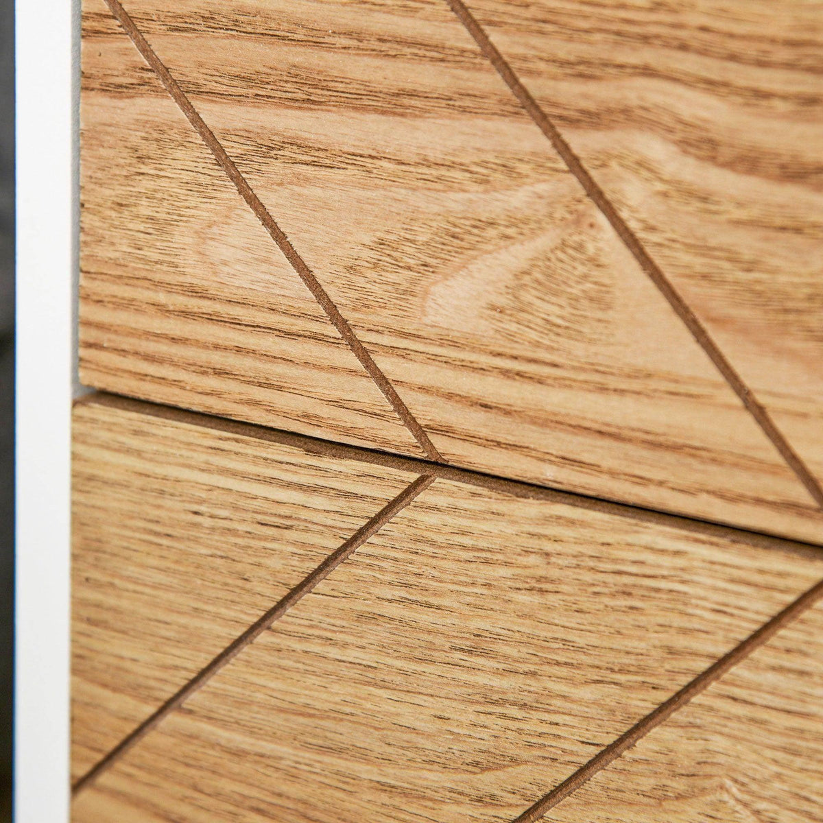Lower drawer panel with light wood geometric pattern and recessed pull handle.