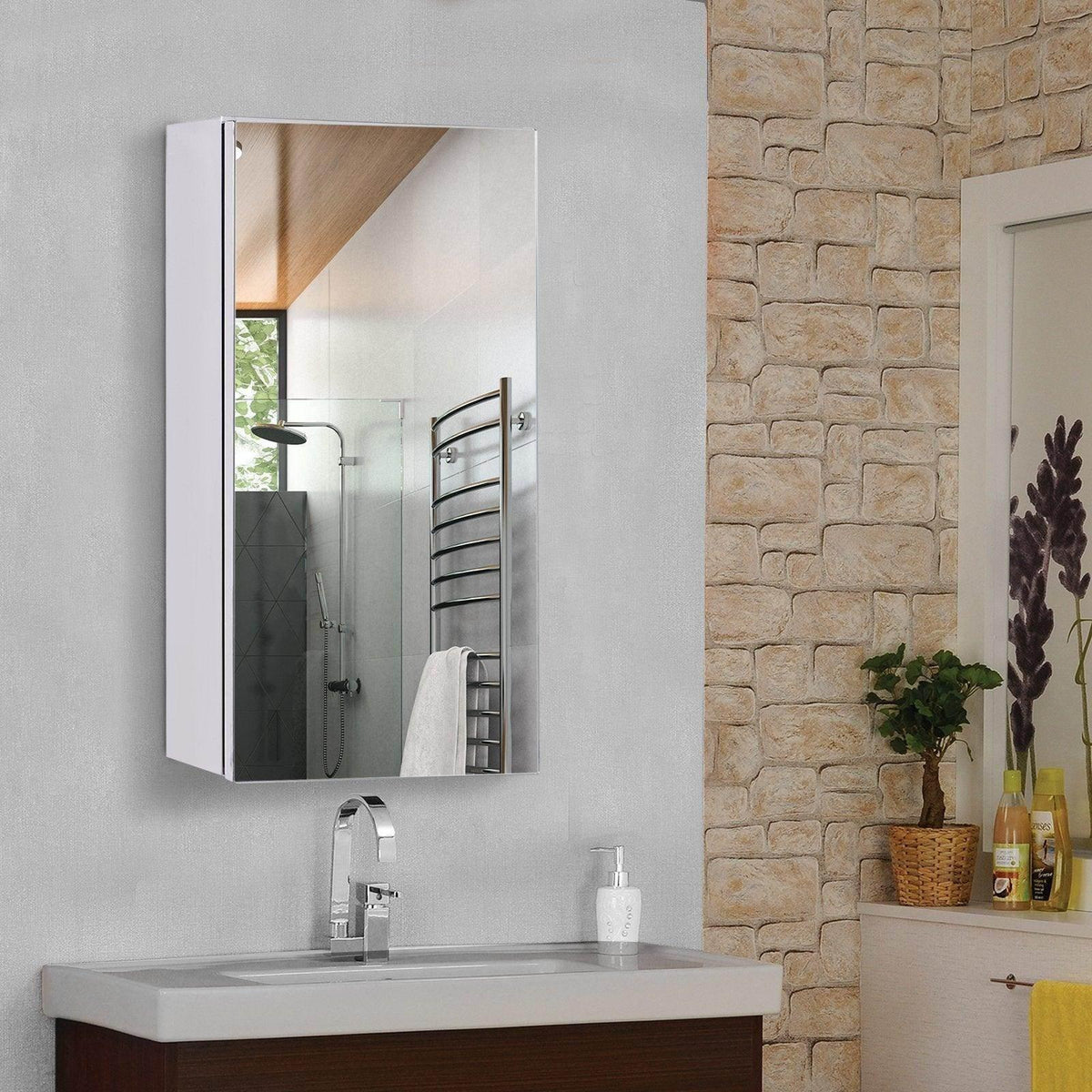 White bathroom medicine cabinet with mirror above sink, modern vanity, stone accent wall, towel warmer reflection