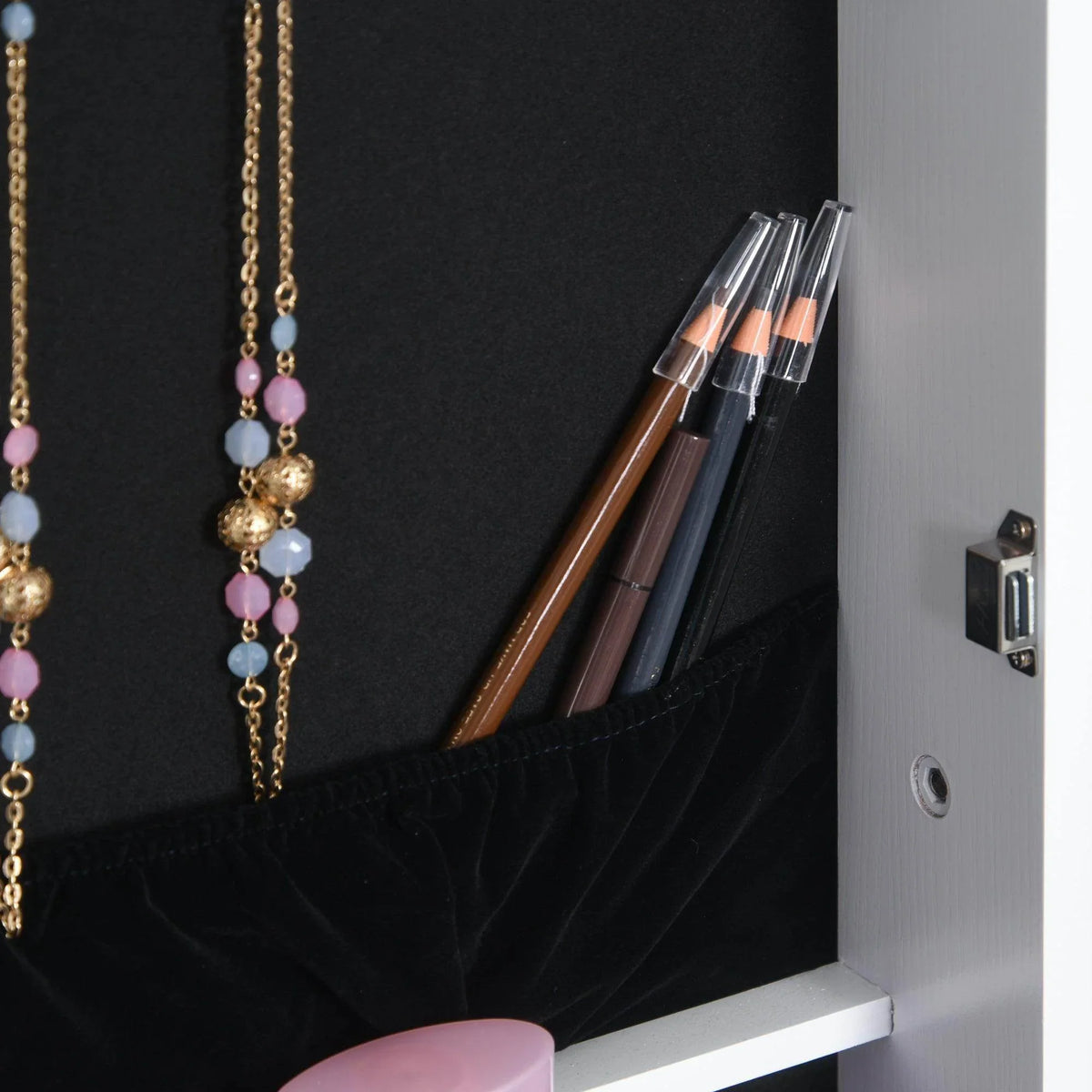White jewelry cabinet interior with necklace hooks and makeup brush storage area