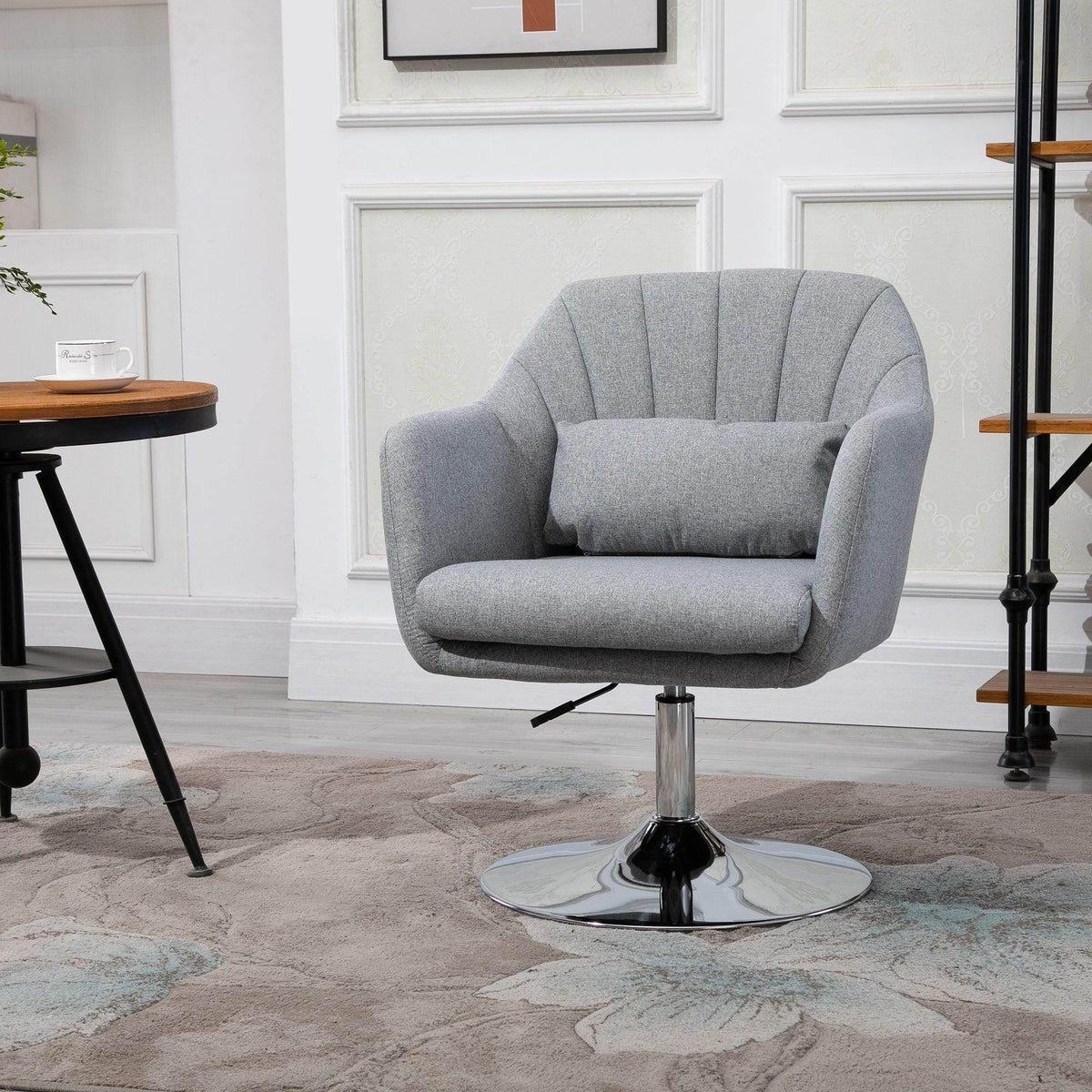 Light grey upholstered swivel tub chair with round metal pedestal base and padded arms
