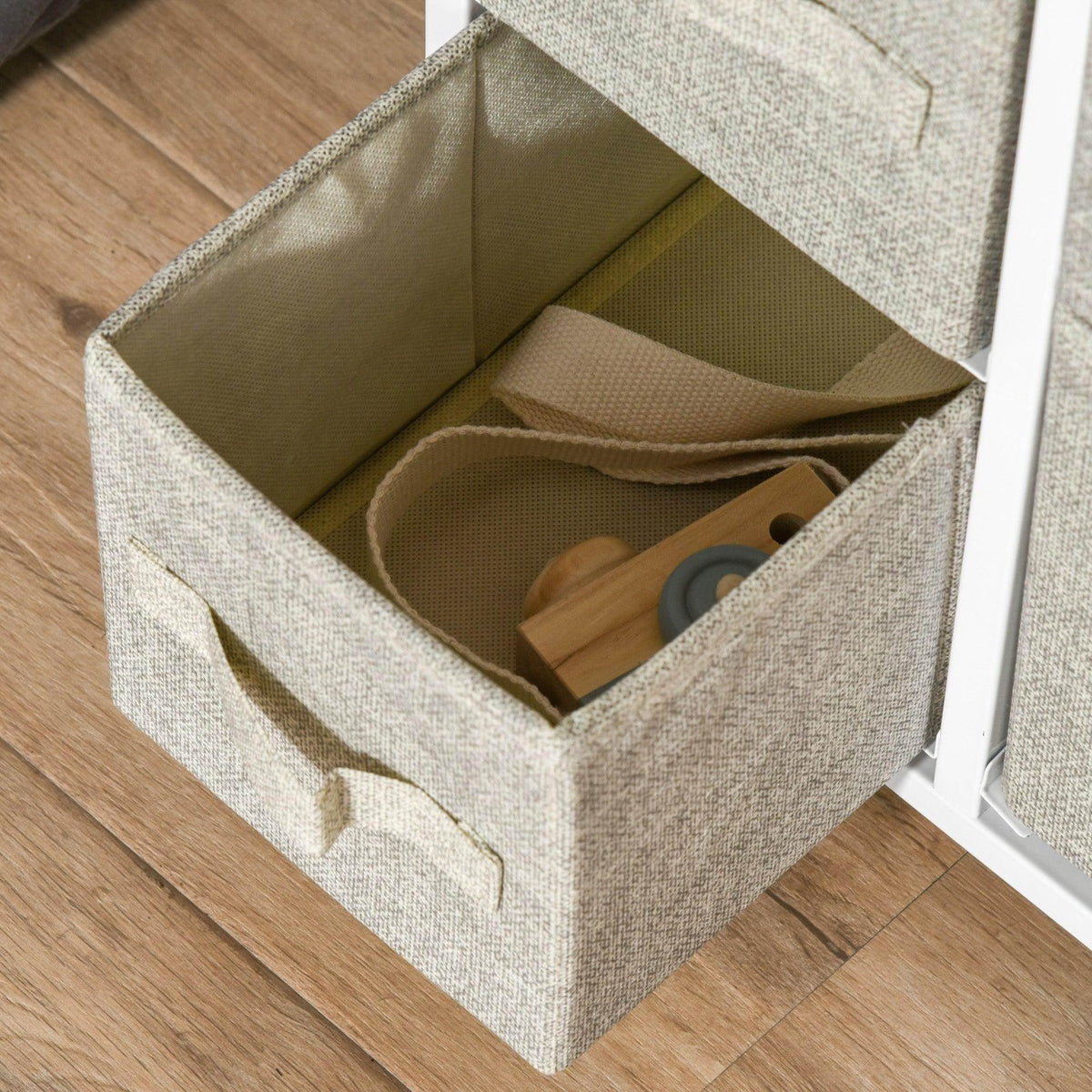 Open drawer in a vertical linen drawer cabinet with gray fabric and beige pull handles