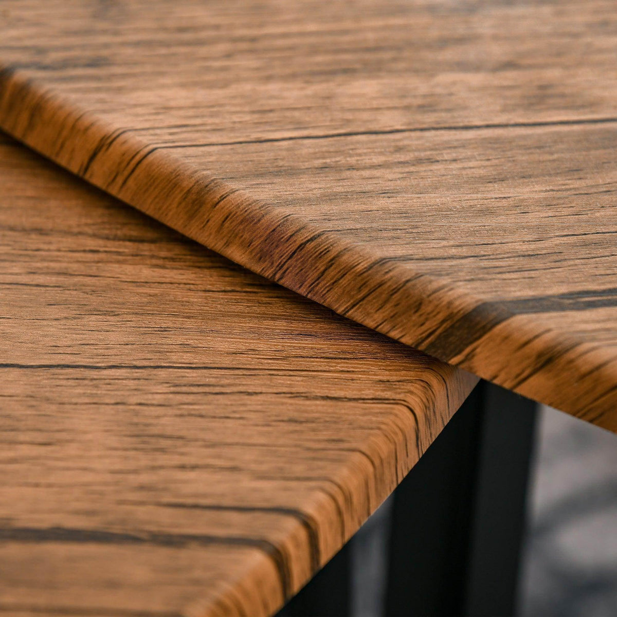 Wood-grain tabletop with rounded edges and black metal legs, nesting table detail