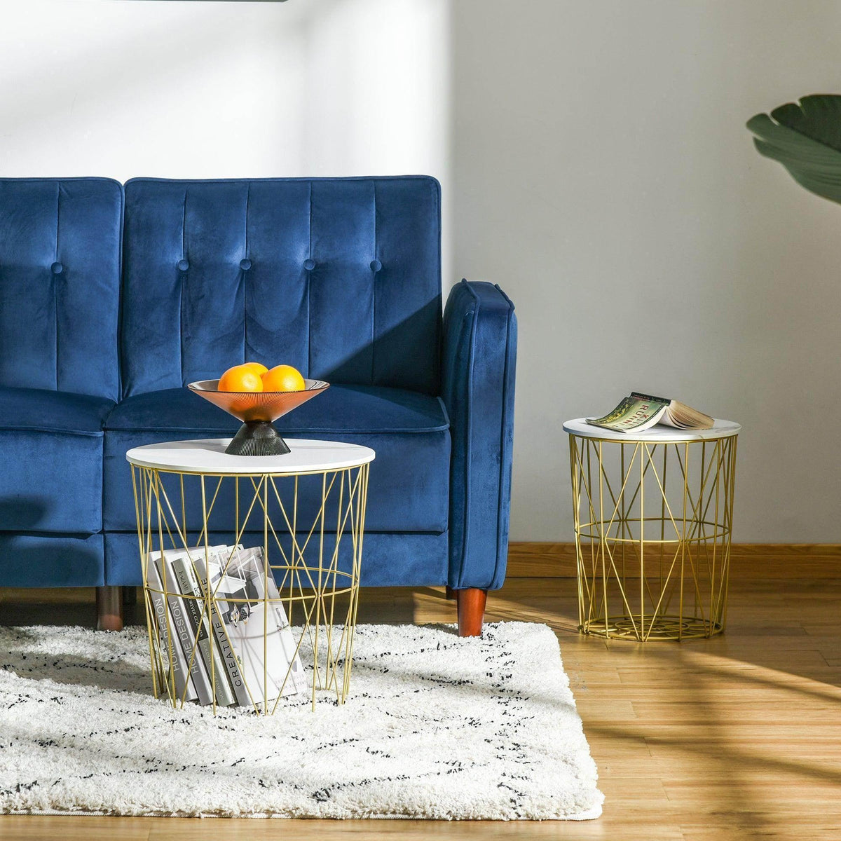 Round white nesting side table with gold wire cage base for storage