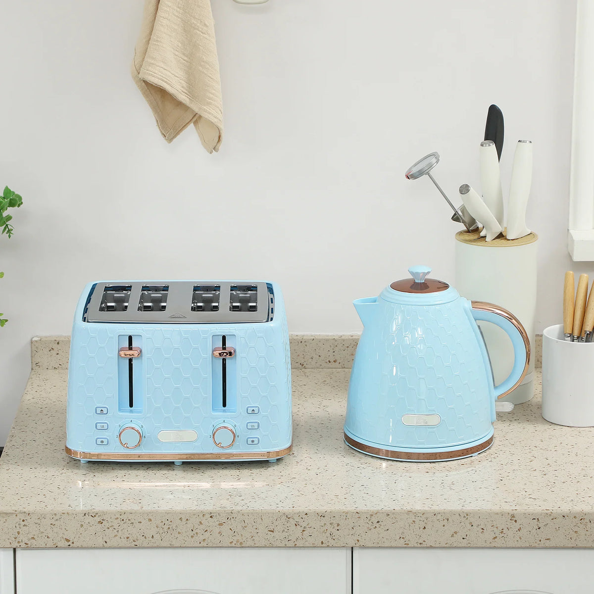 Light blue 4-slice toaster and electric kettle set on countertop, honeycomb pattern.