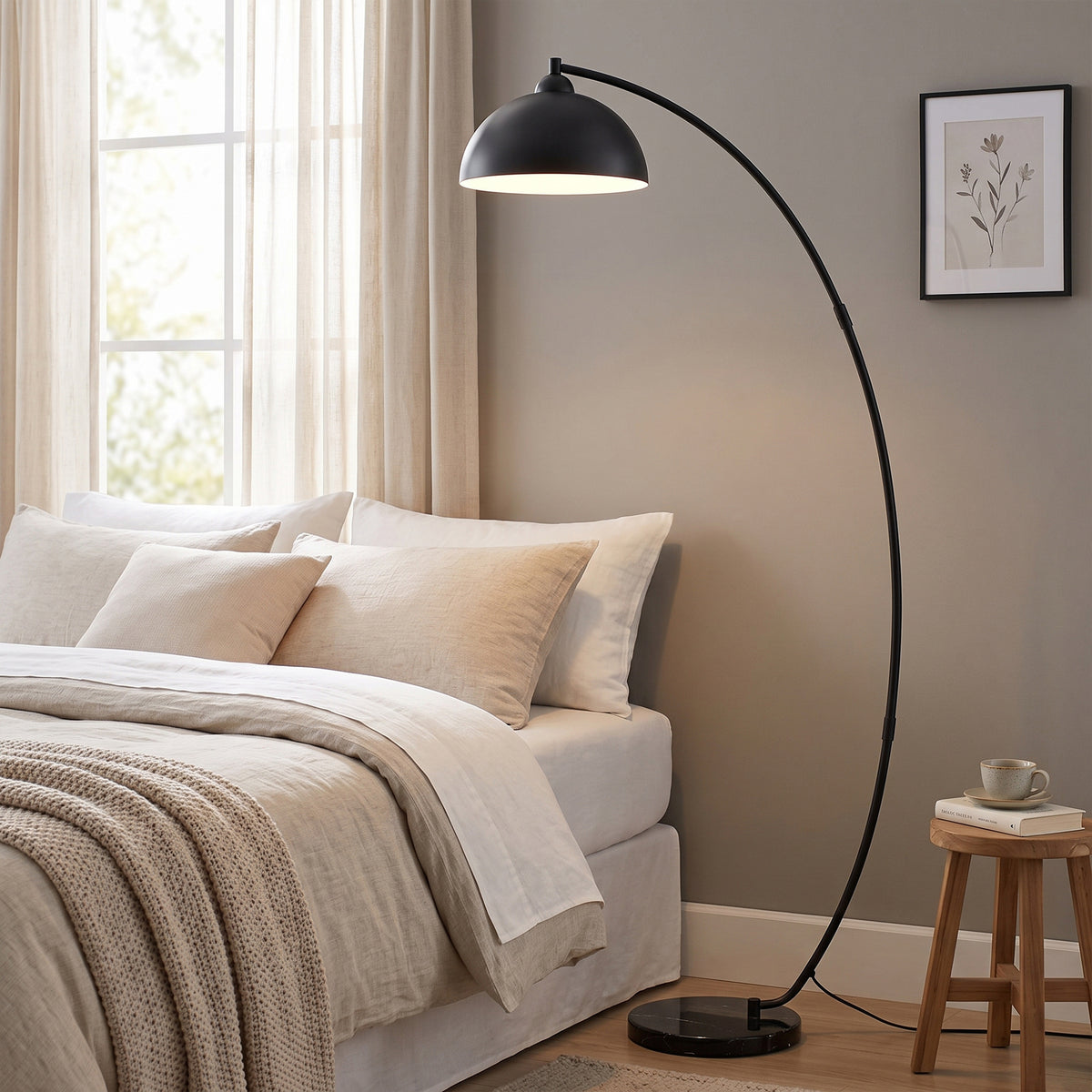 Black arc floor lamp with bowl-shaped shade and round marble-look base
