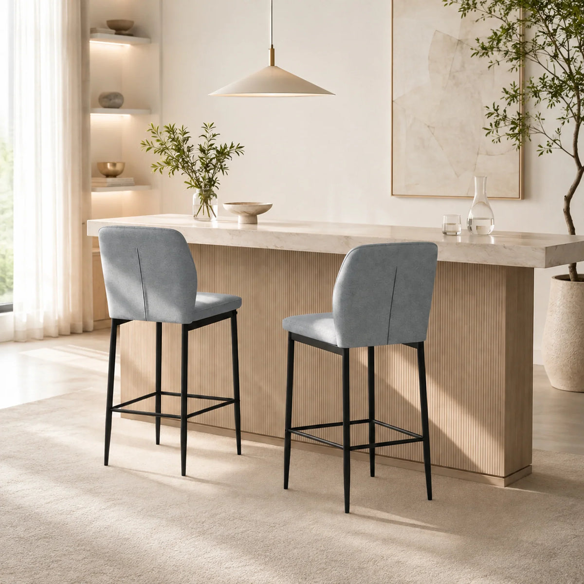 Two grey upholstered bar stools with tall backrests, footrests, and black metal legs