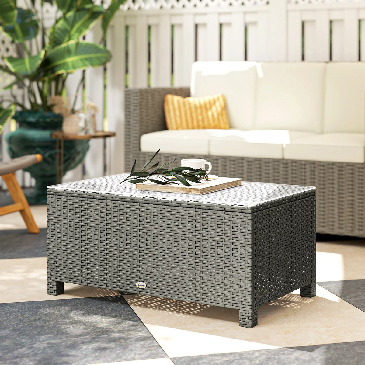 Light grey PE rattan coffee table with glass top, woven sides, and short base