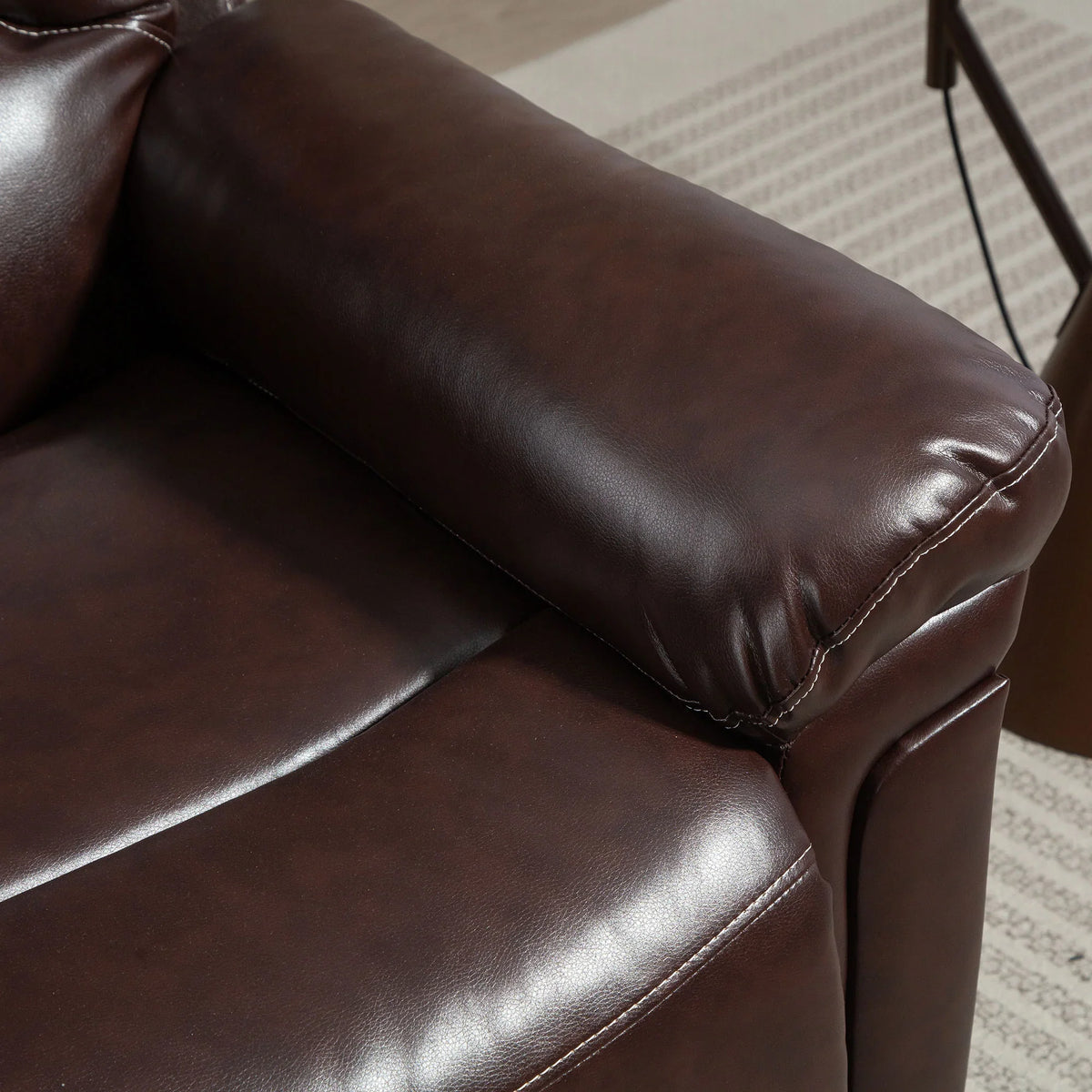Brown PU leather riser recliner chair armrest and padded seat detail.