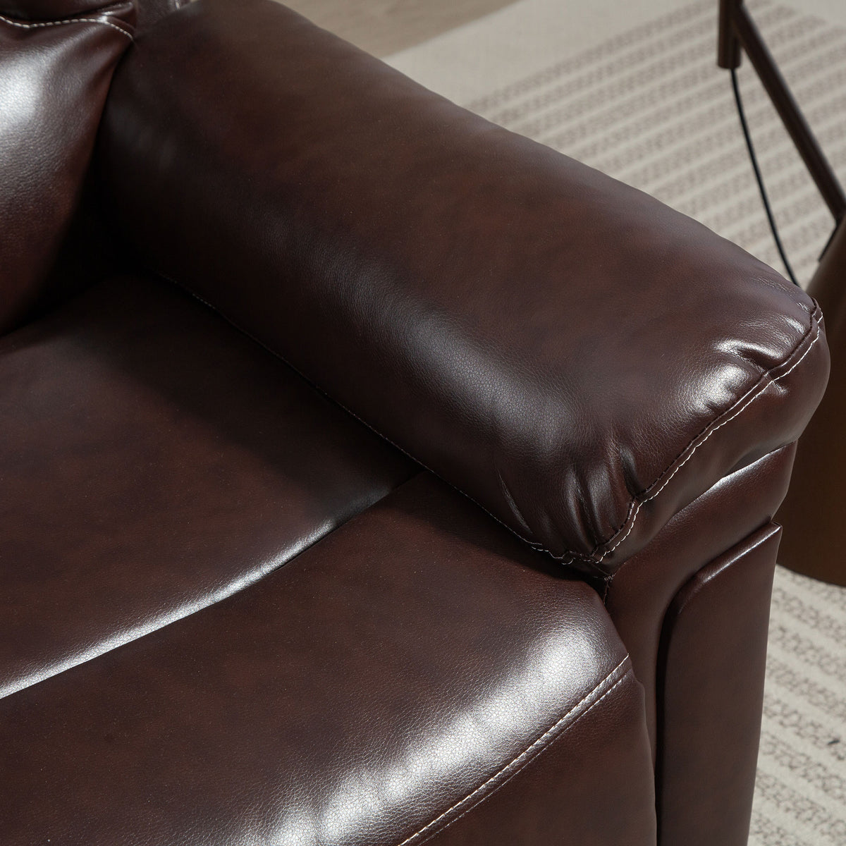 Brown PU leather riser recliner chair armrest and padded seat detail.
