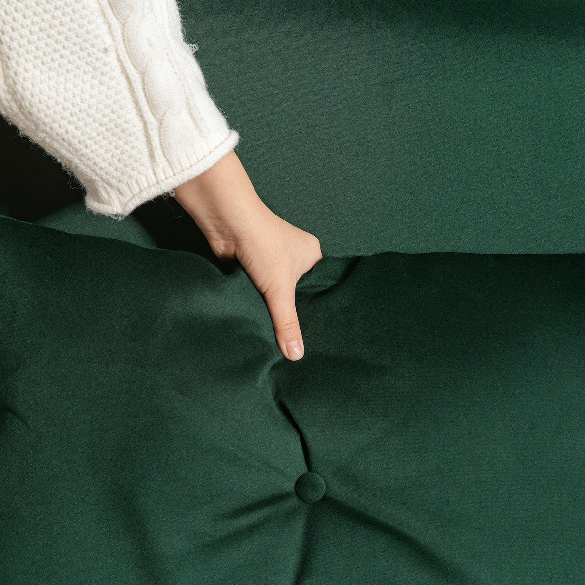 Close-up of green tufted sofa bed fabric with stitched pillow button