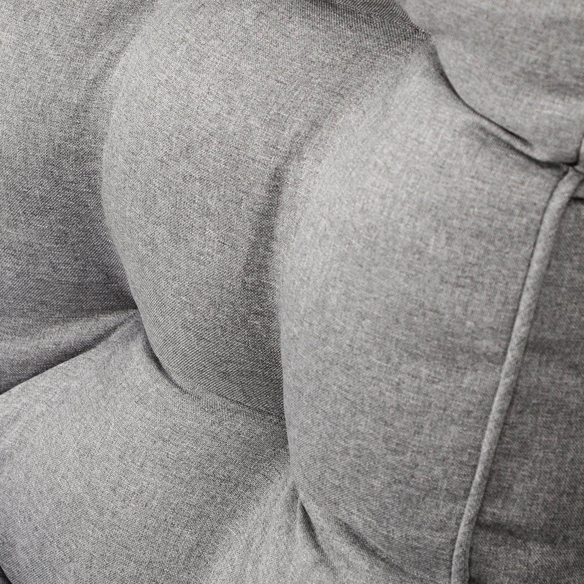 Grey upholstered cushion with stitched seams and molded armrest padding