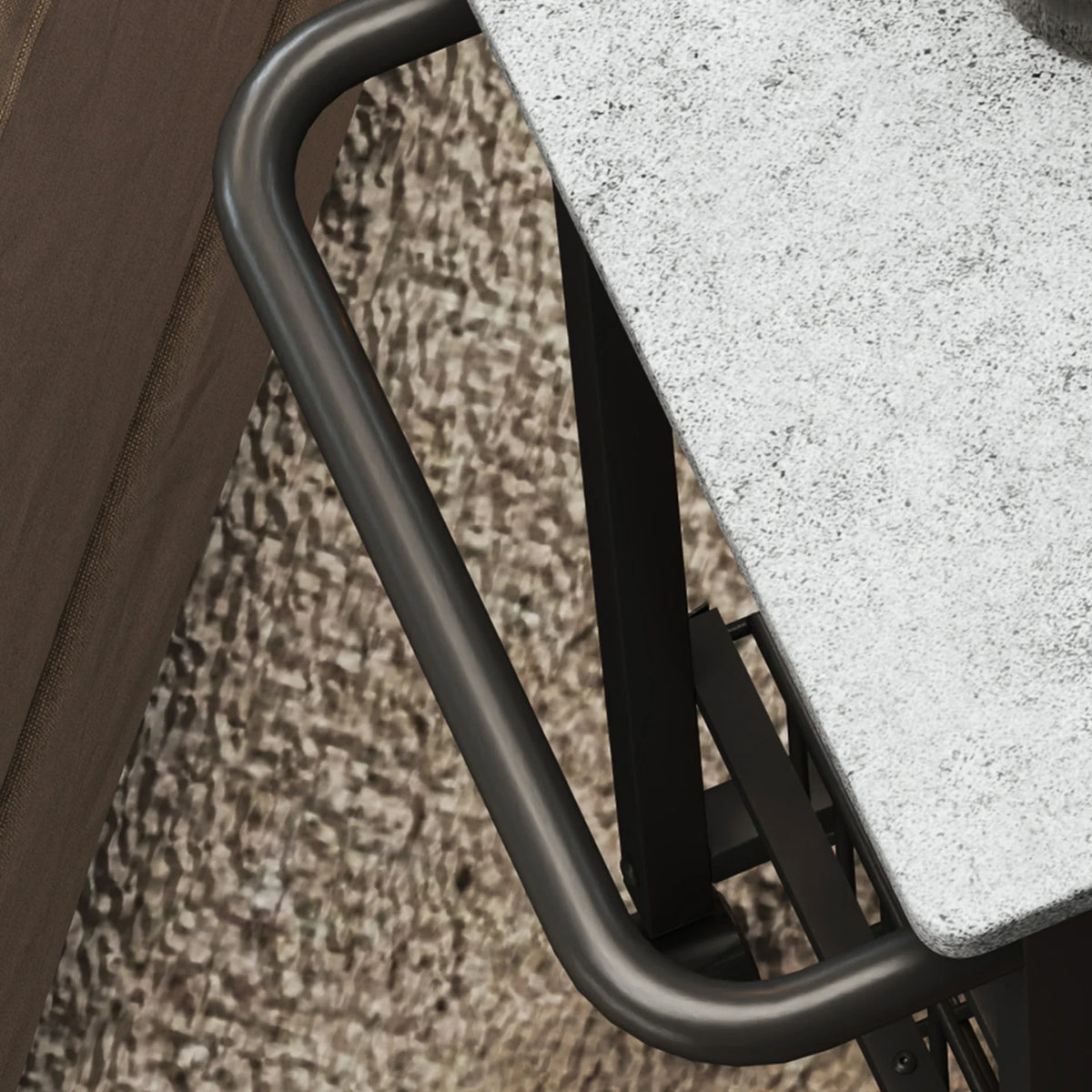 Corner detail of grey handle and black frame edge on a mobile kitchen island cart.