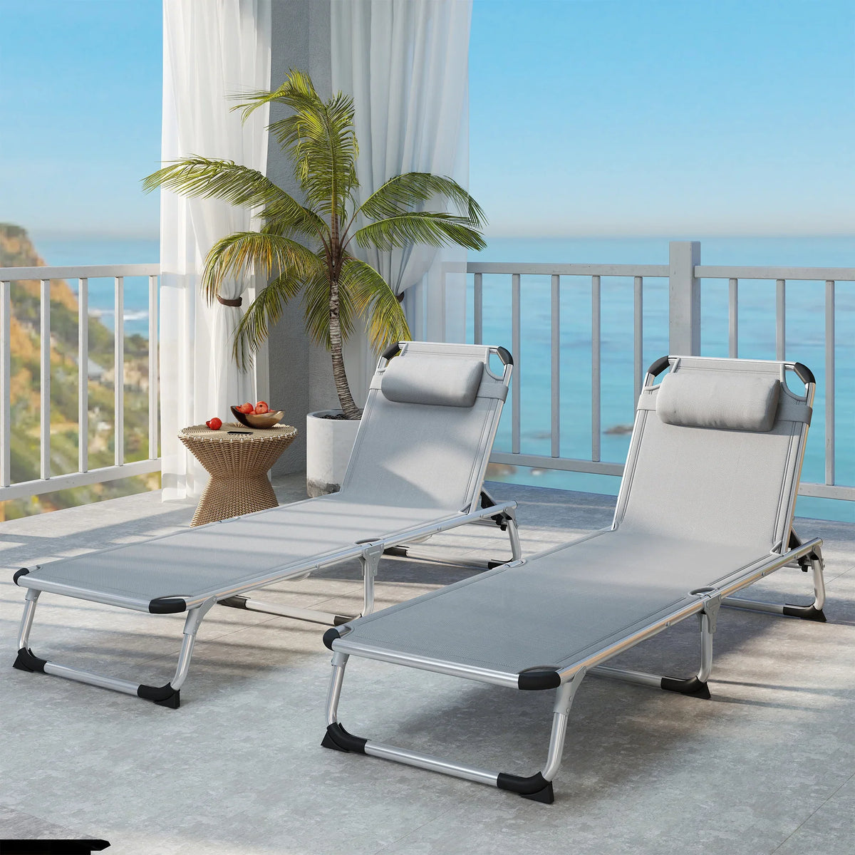 Pair of light grey foldable sun loungers with pillows and adjustable recline backrests.