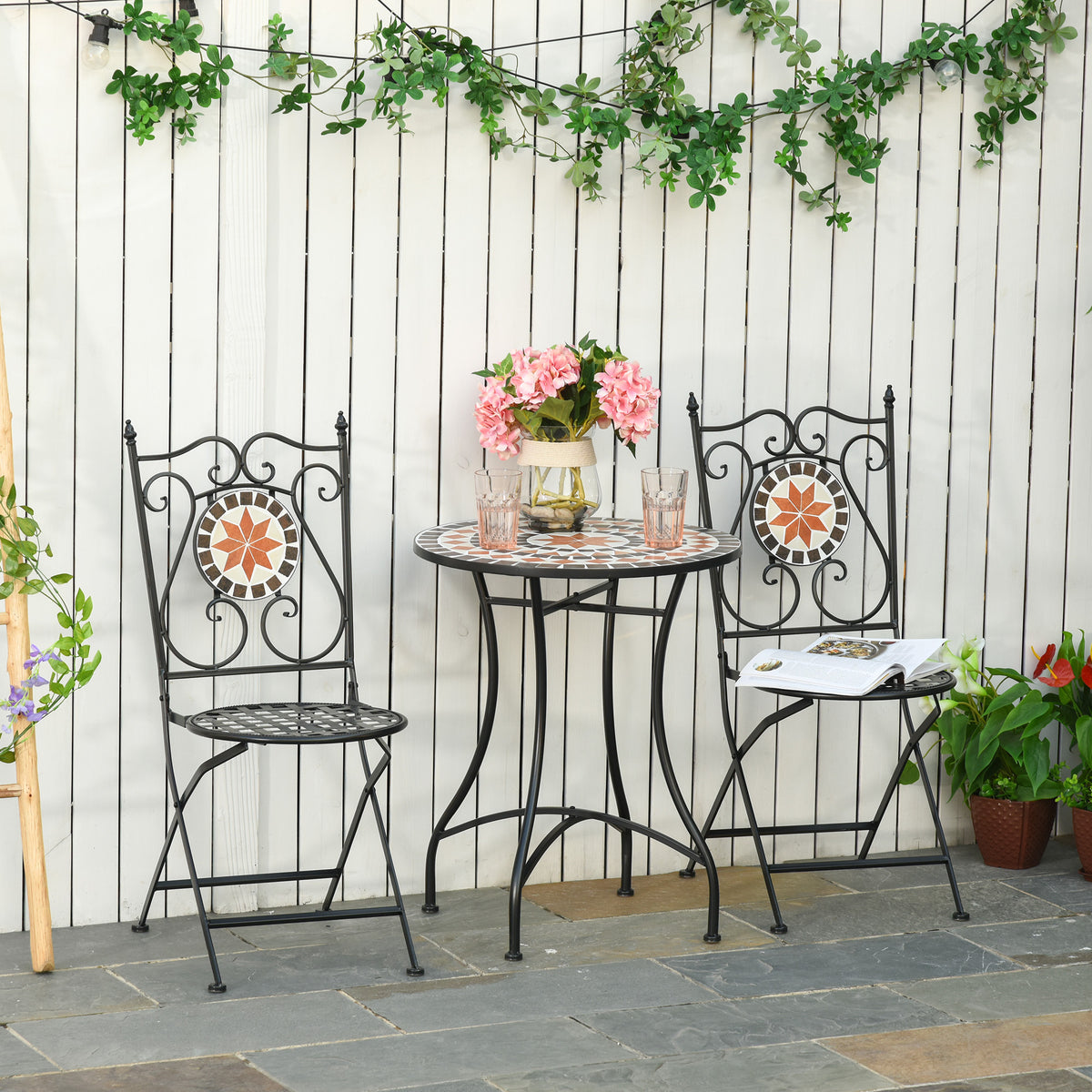 Three-piece outdoor bistro set: round mosaic table and two black folding chairs