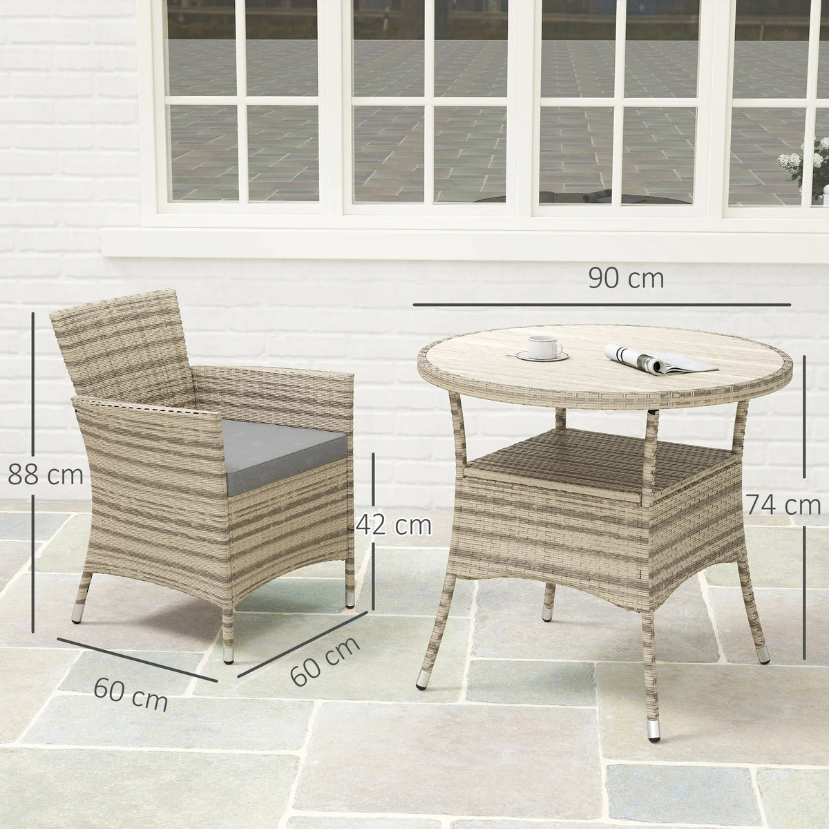 Grey rattan armchairs and round two-tier table on patio, shown with dimensions