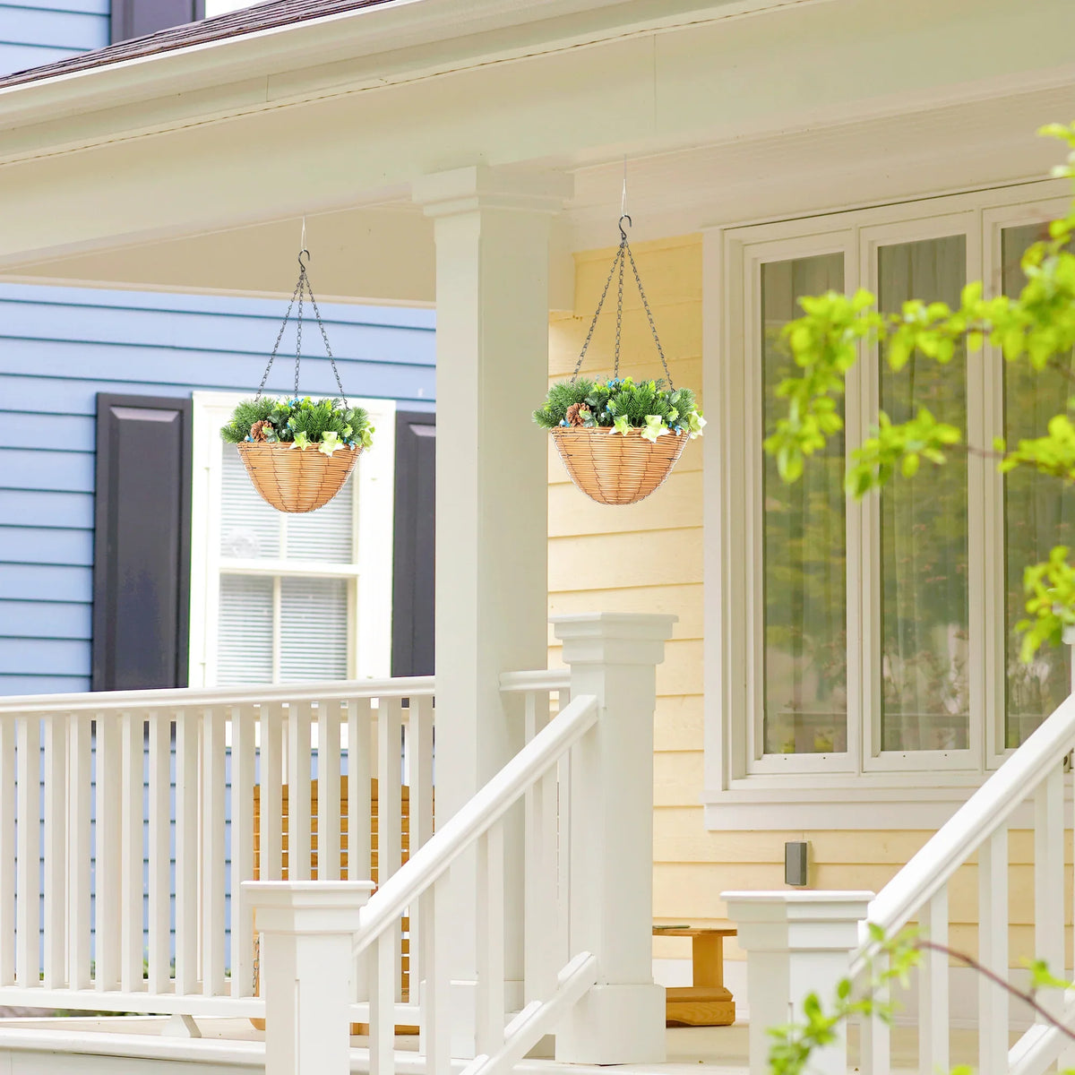 Two hanging faux flower baskets on a porch railing with green foliage and blue blossoms