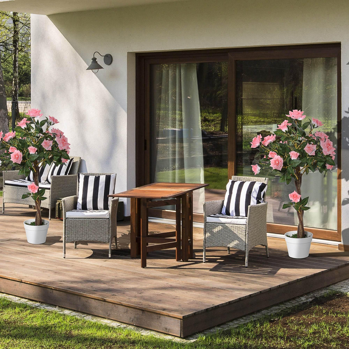 Set of 2 artificial pink rose plants in white decorative pots on patio