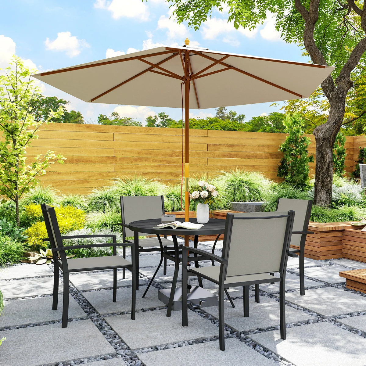 Dark grey patio dining set with round table, four chairs, and open umbrella in yard.