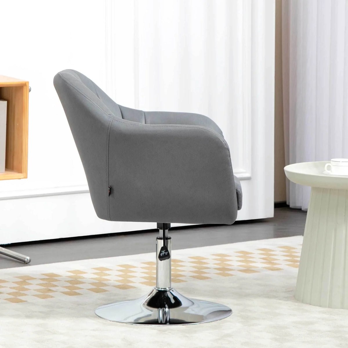 Grey swivel accent armchair with curved backrest and round chrome base
