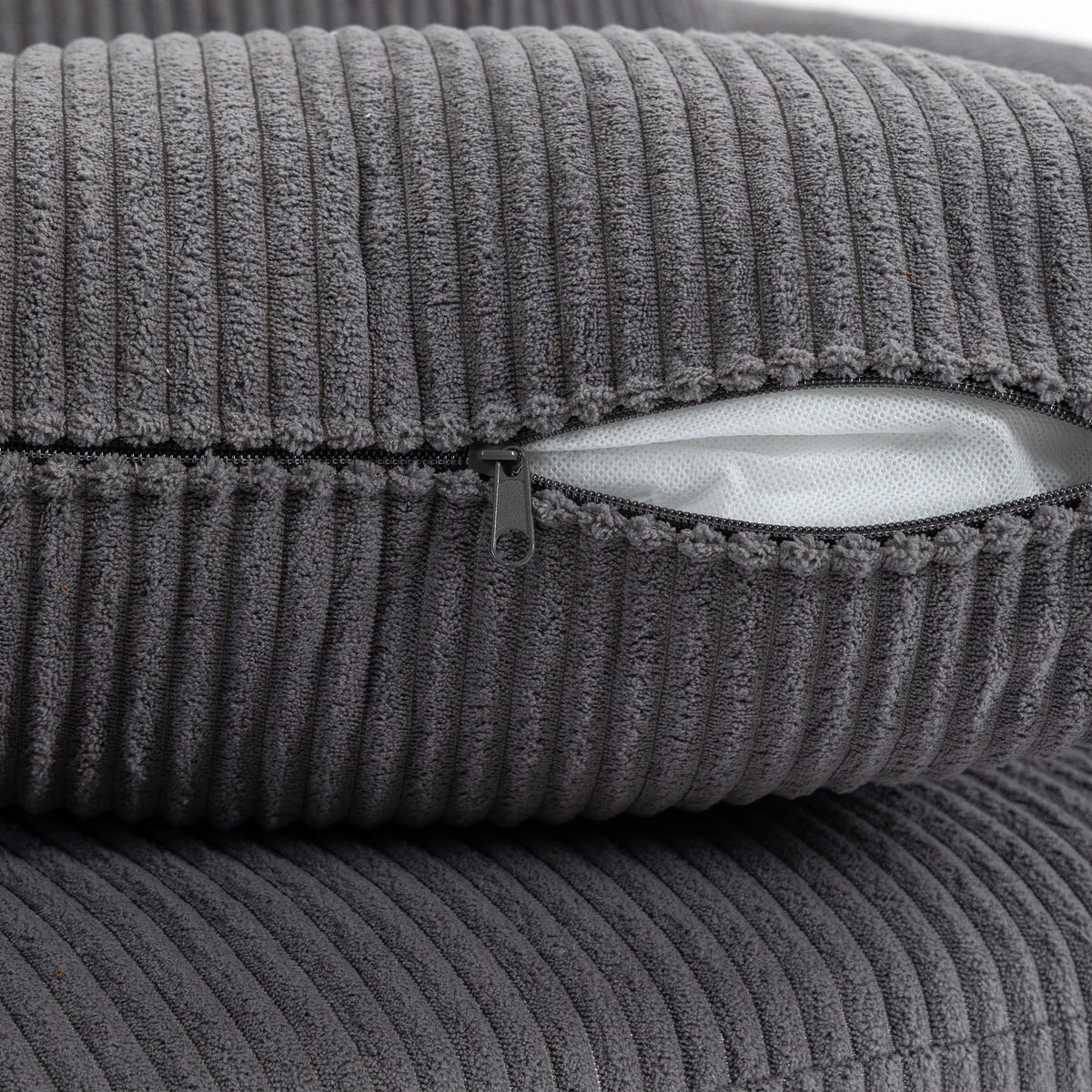 Dark grey corduroy close-up showing ribbed fabric texture and cushion seam