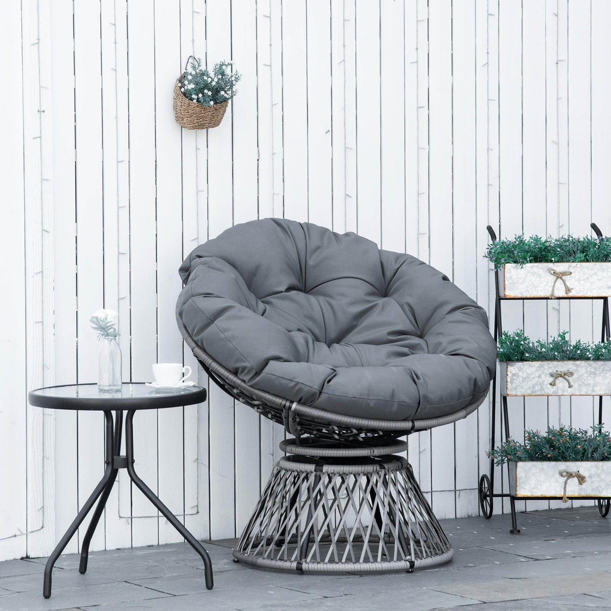 Round papasan-style swivel rattan chair with gray padded cushion and woven base