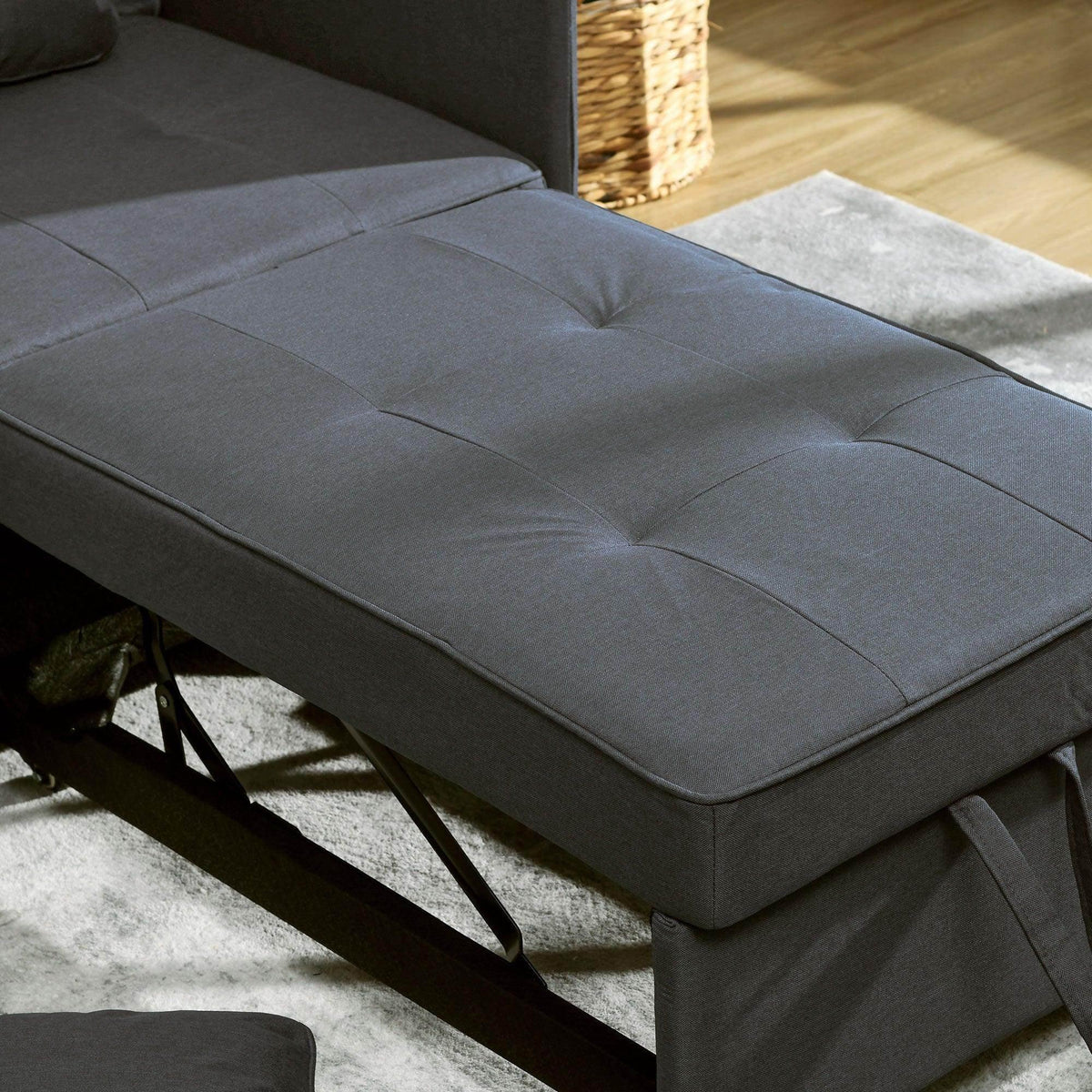 Grey fold-out bed surface with center seam and padded edges, convertible chair bed