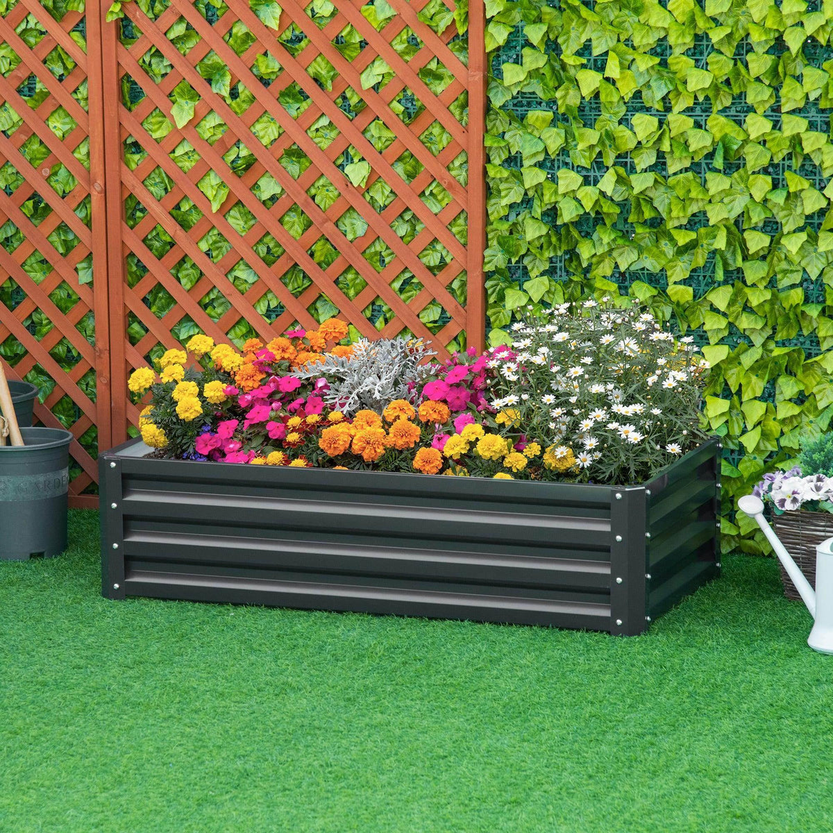 Grey raised garden bed planter box with front slatted sides and colorful flowers