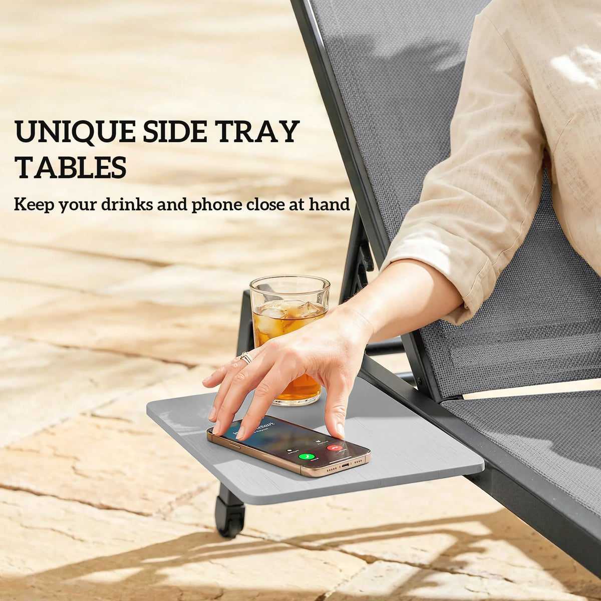 Grey sun lounger side tray with drink holder and phone on tabletop