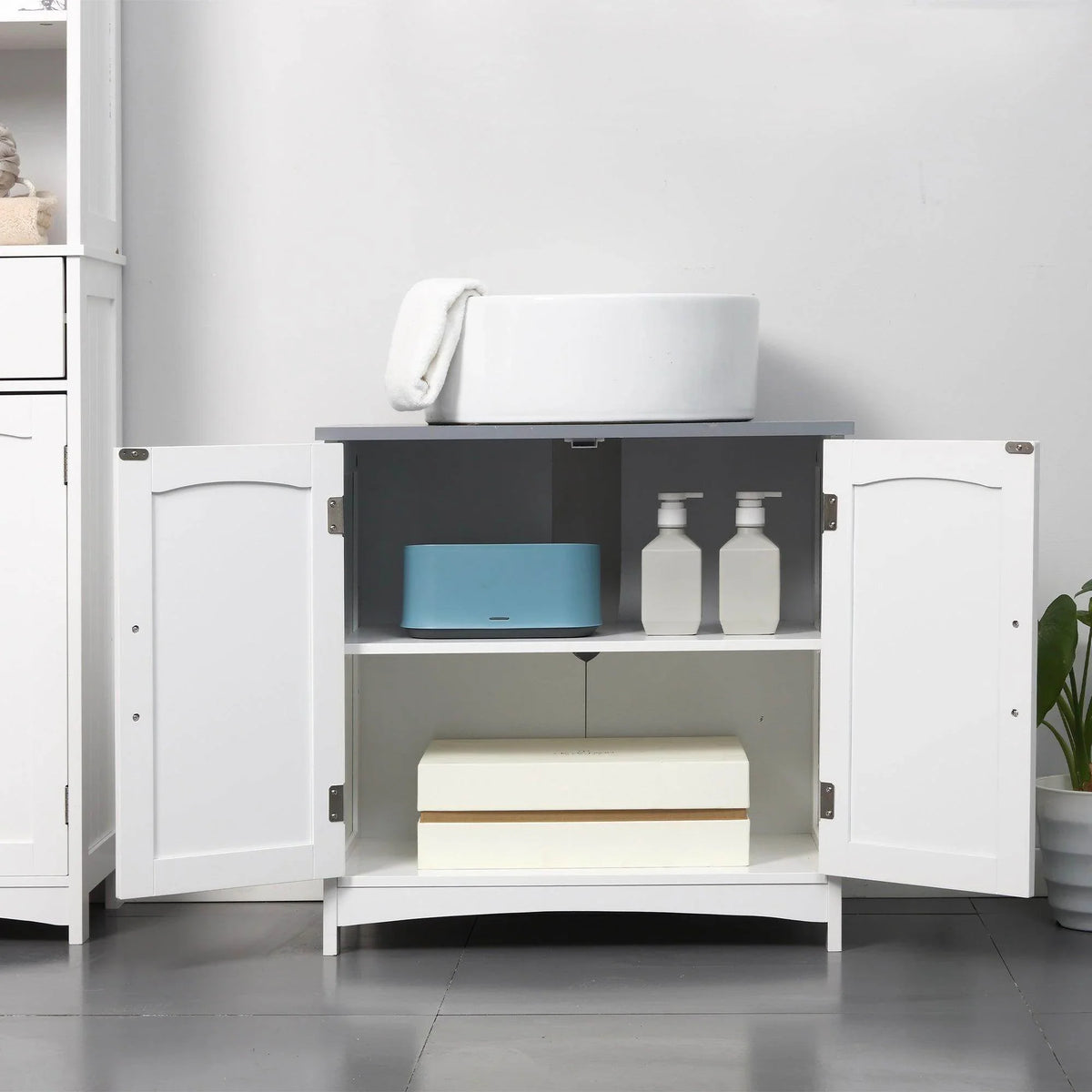 White under-sink cabinet with double doors open showing shelves and storage items