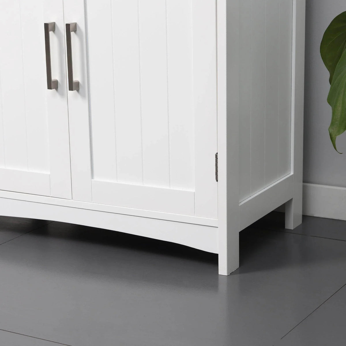 White cabinet side with double doors, vertical panel details, and metal handle pulls
