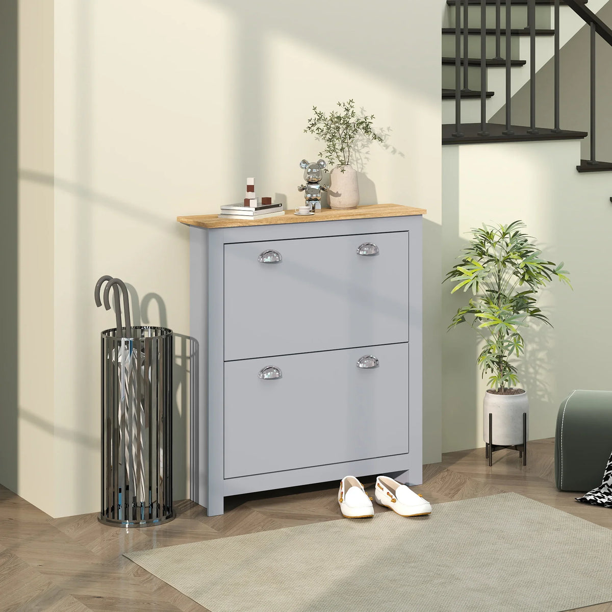 Grey shoe cabinet with two flip doors, two drawers, and a light wood top