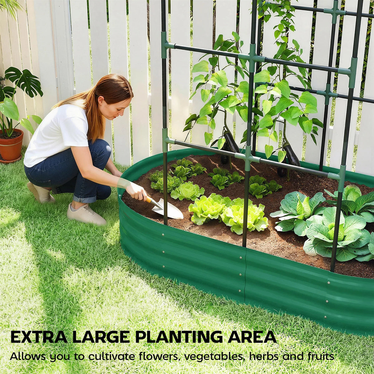Green raised garden bed with arched trellis and soil, person planting leafy greens