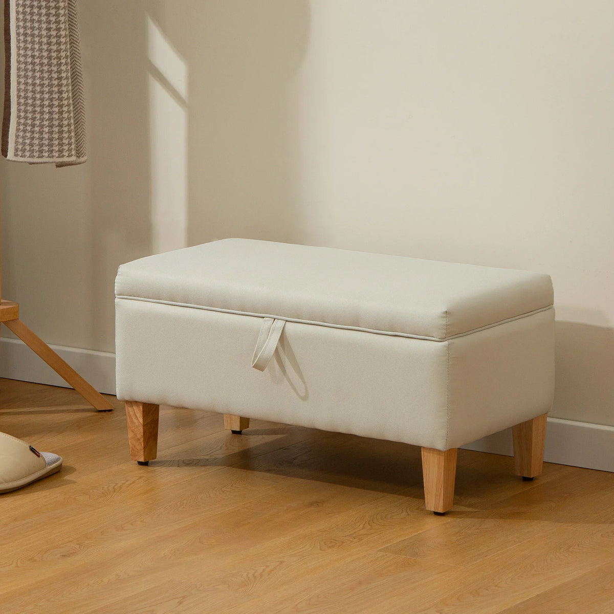 Beige upholstered storage ottoman with cushioned lid and wooden legs