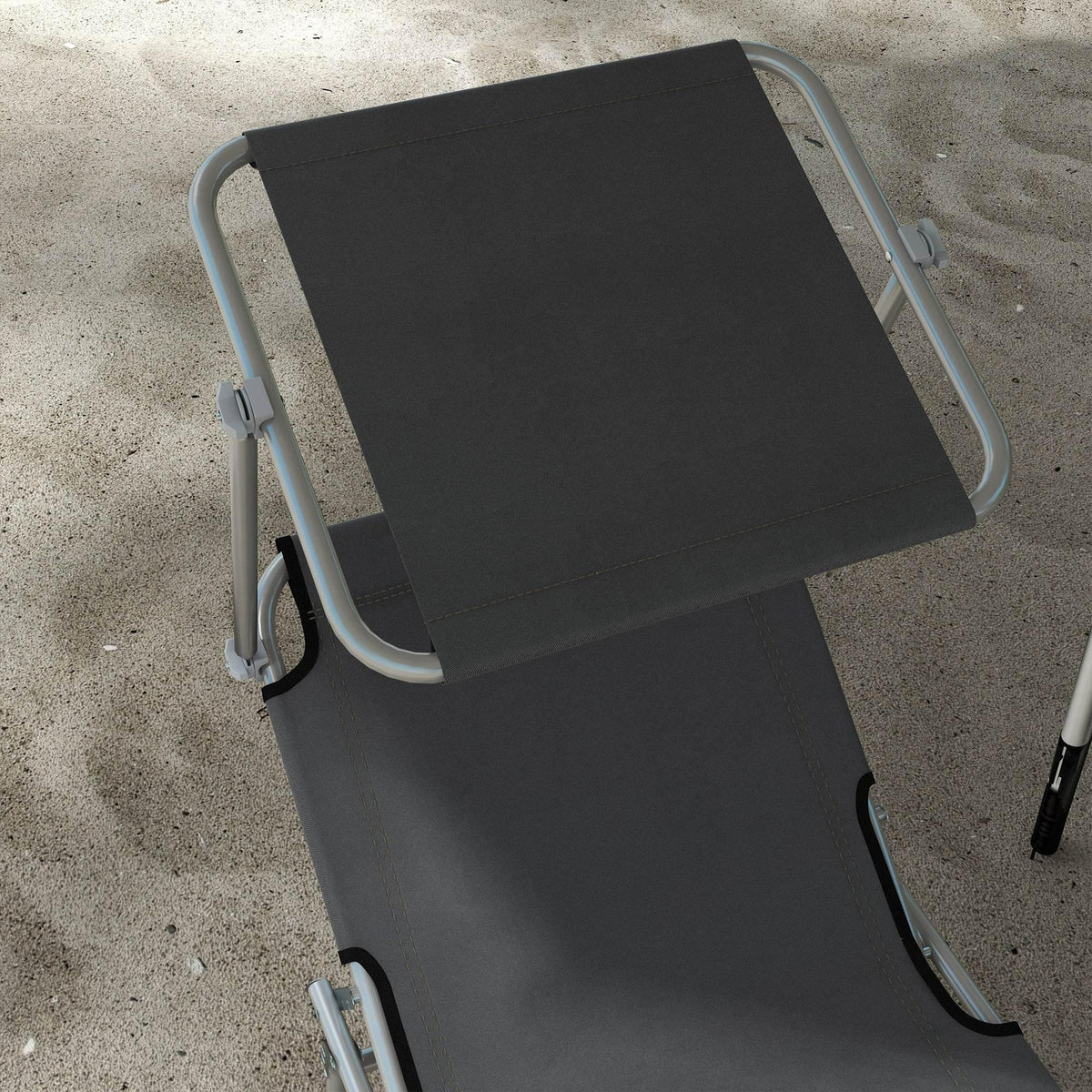 Dark grey reclining sun lounger seat pad with metal frame on outdoor ground