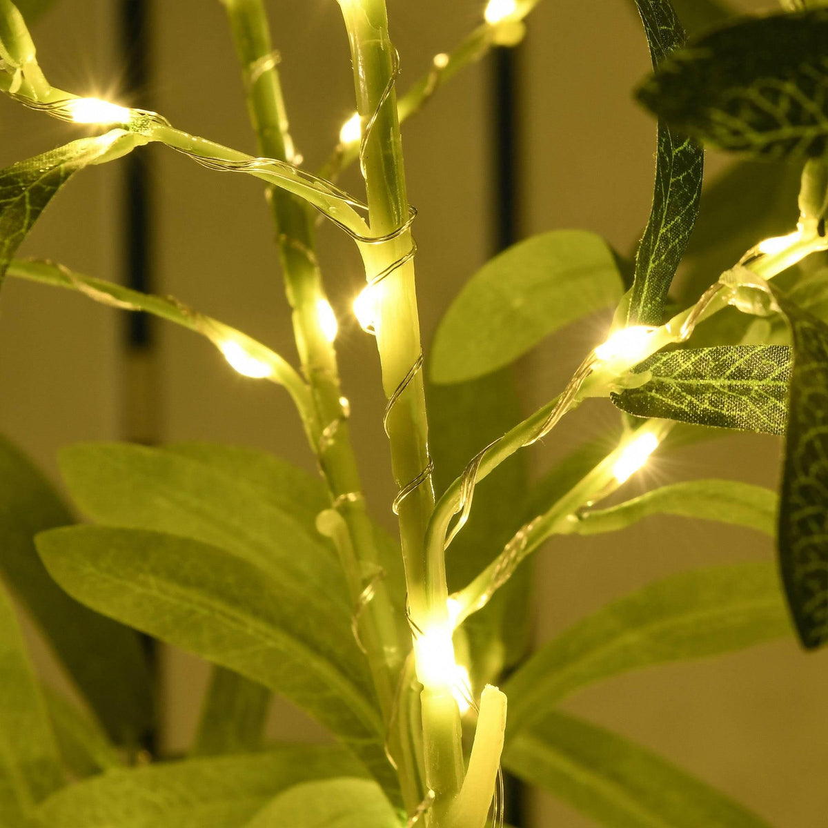 Warm white LEDs glowing on olive tree leaves and stems