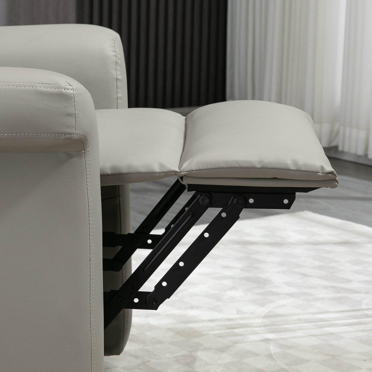 Grey recliner chair showing extended footrest and reclining back cushion