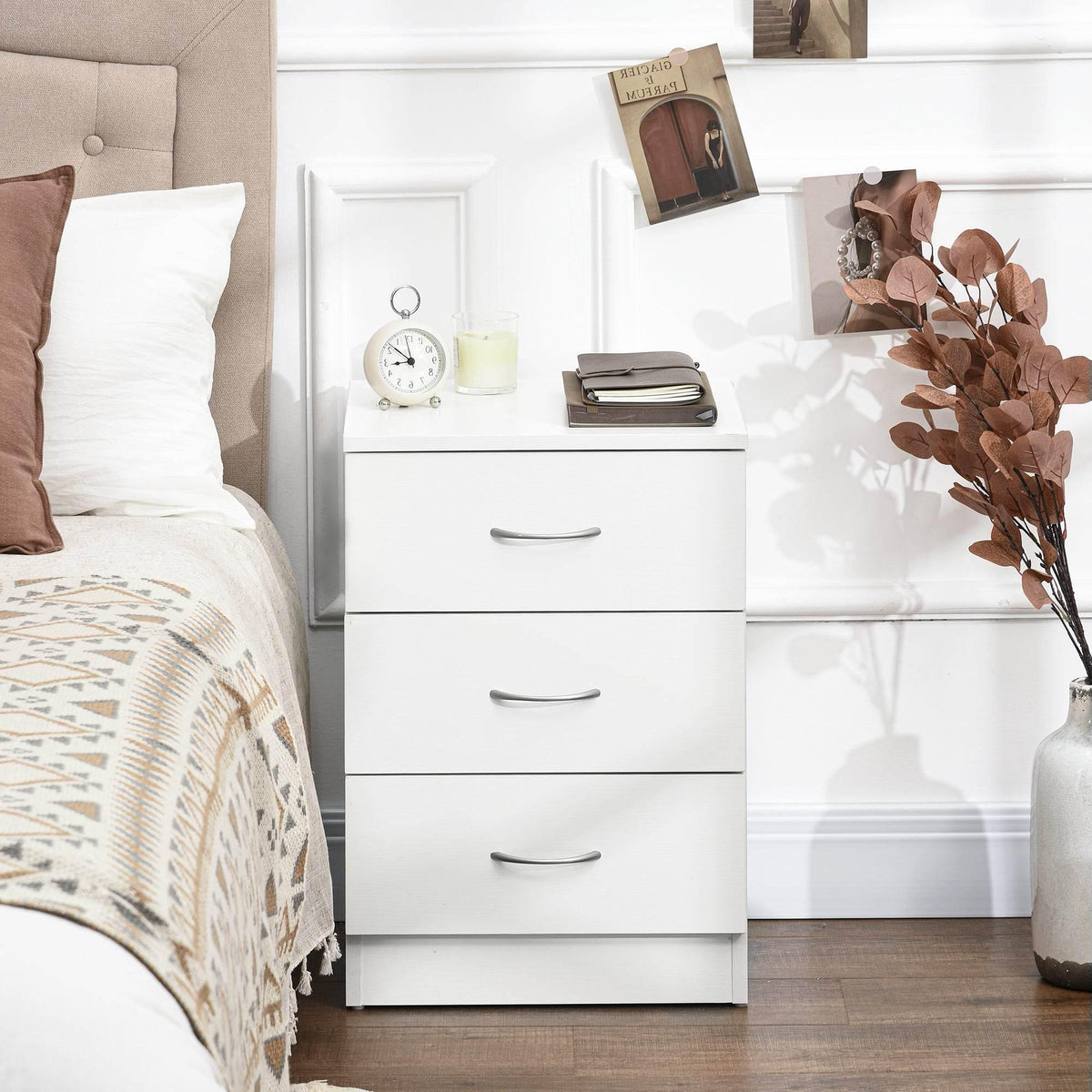 White three-drawer nightstand with curved pulls on a dark wood floor
