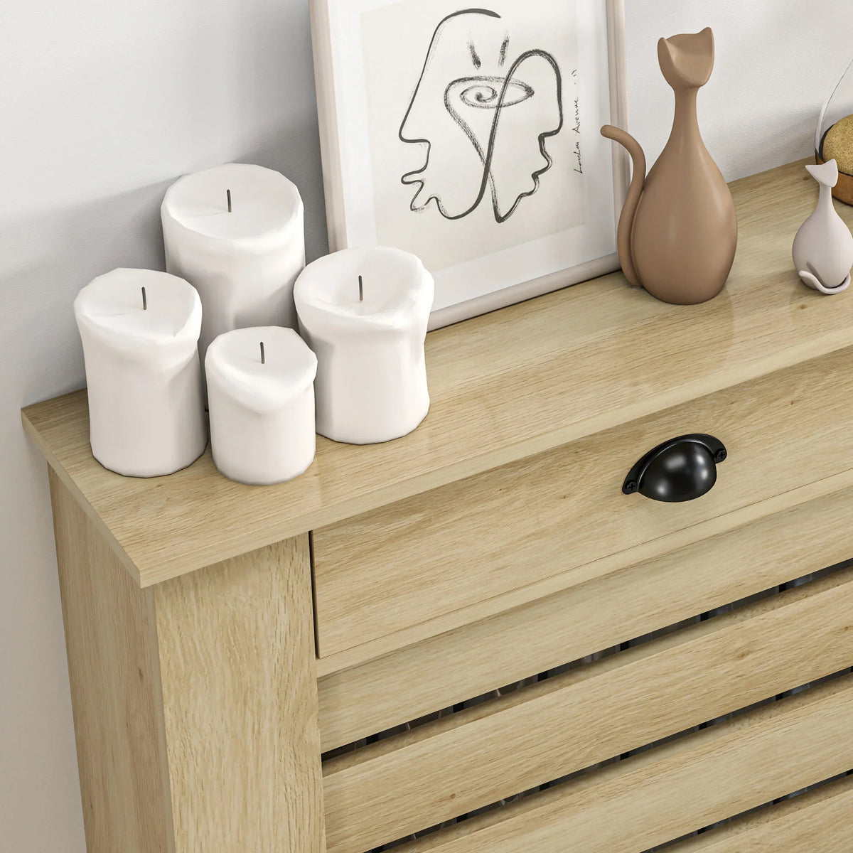 Oak radiator cover with drawer front and black handle, top shelf items and slats
