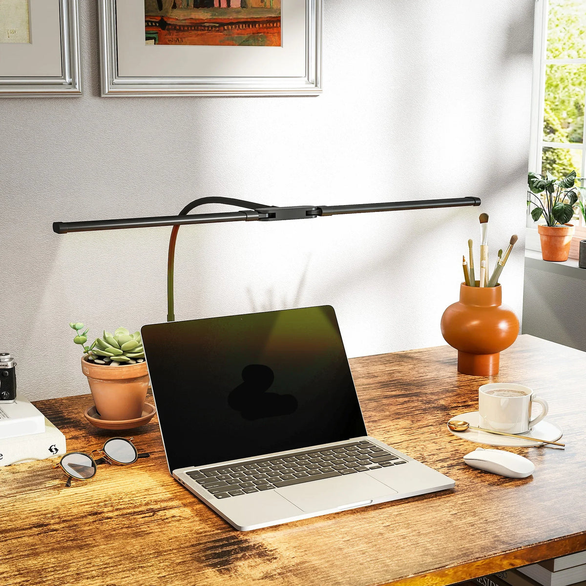 Black dual-head LED desk clamp lamp over wooden office desk