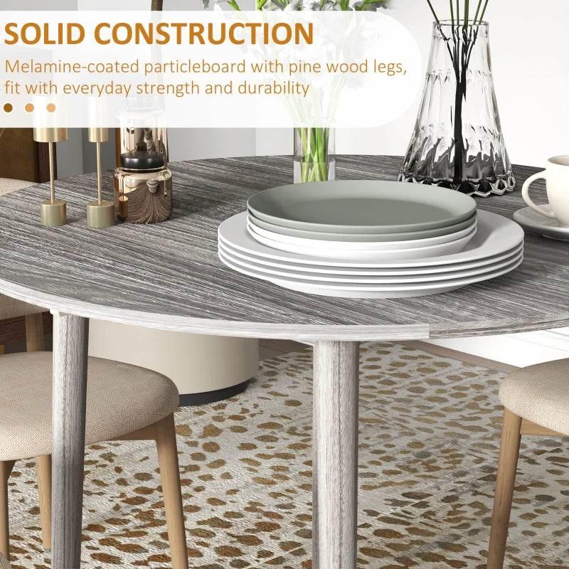 Grey drop-leaf dining table with wood legs and textured tabletop edge, close-up