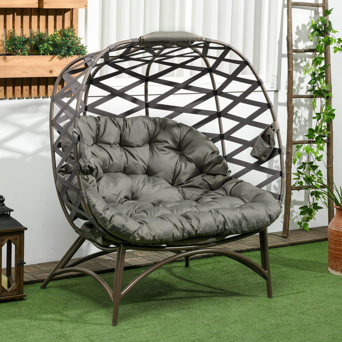 Outdoor egg-shaped patio chair with dark woven frame and tufted gray seat cushion