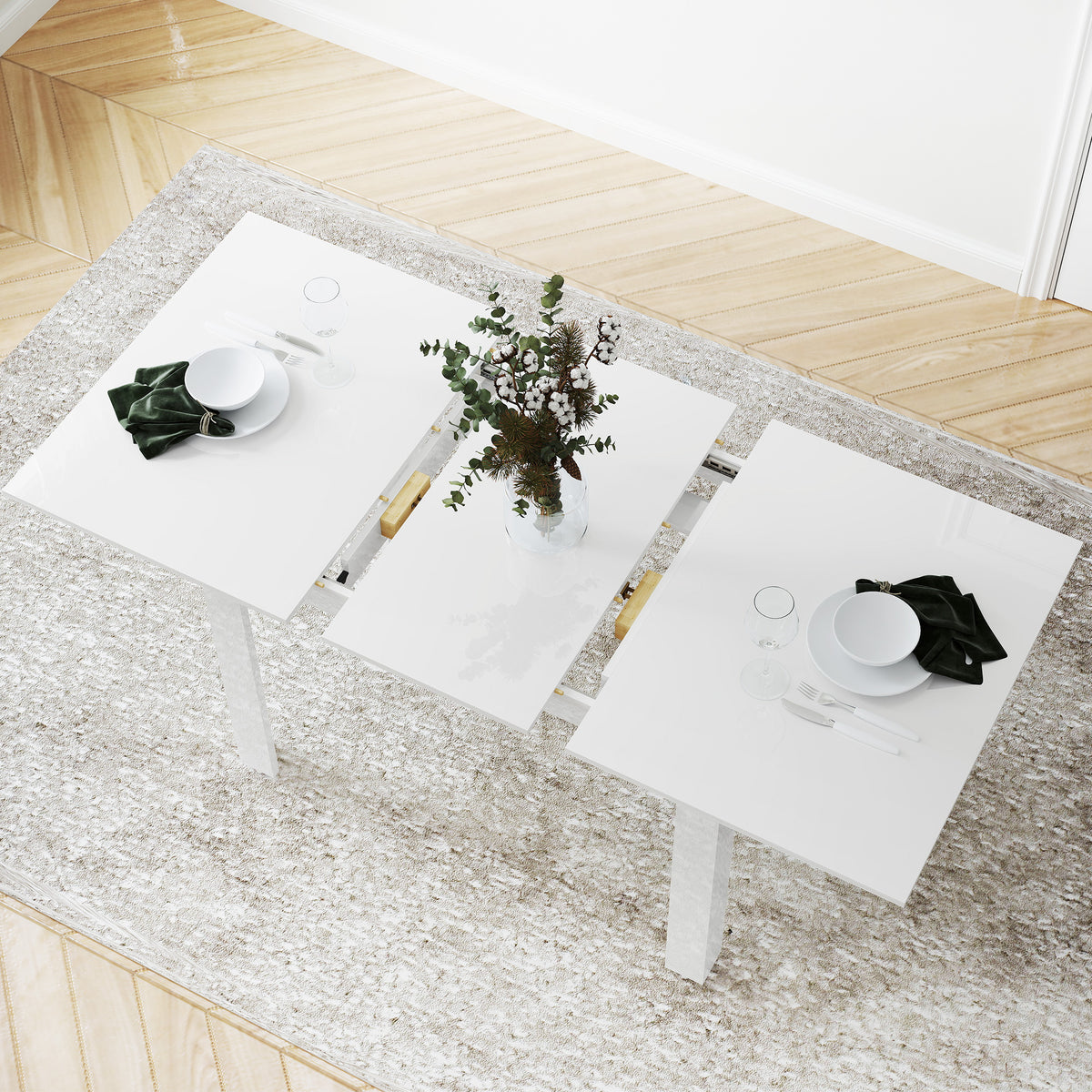 White extendable dining table with glossy top and two square place settings on top.