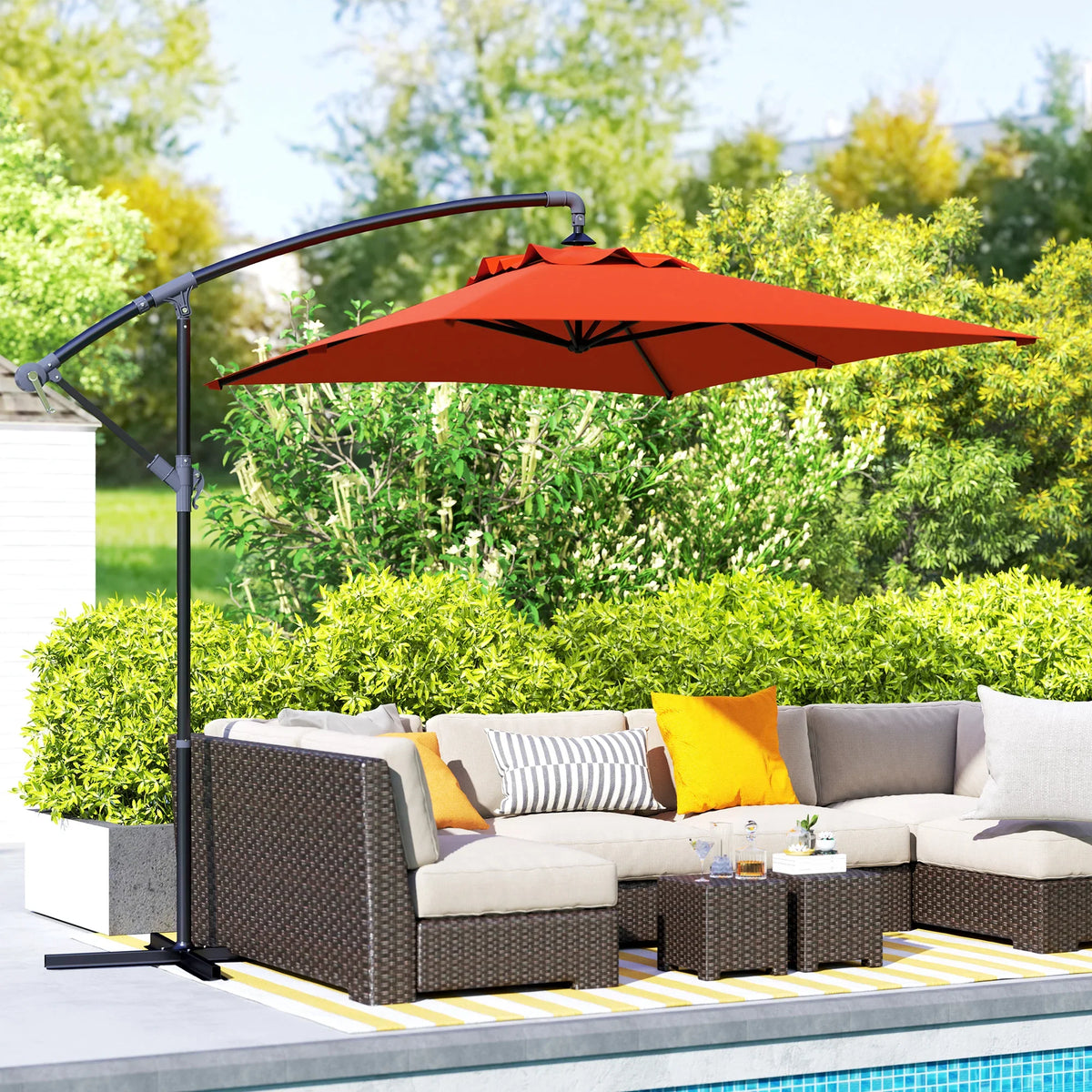 Orange cantilever patio parasol with cross base over outdoor seating set