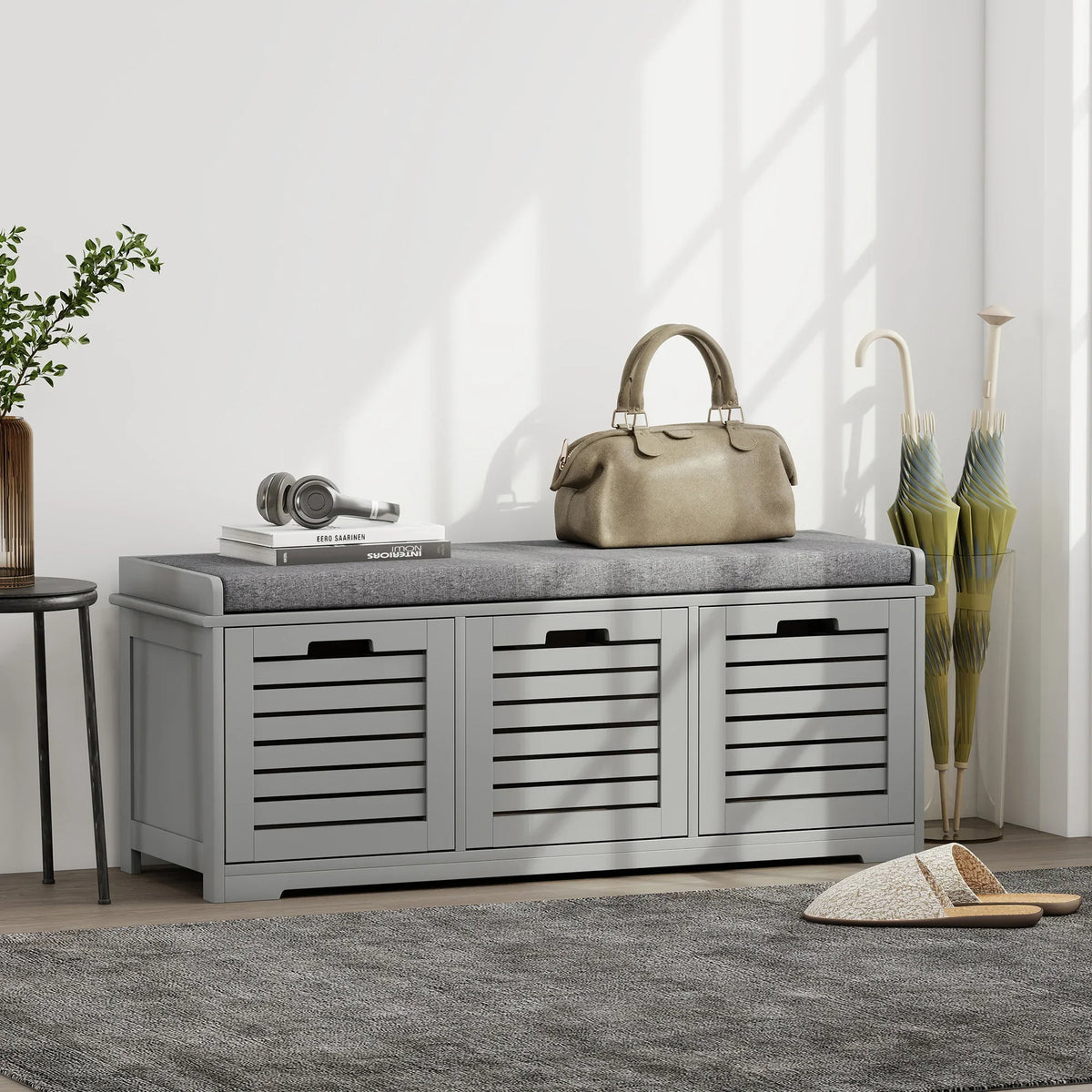 Grey storage bench with cushioned top and three slatted shoe compartments