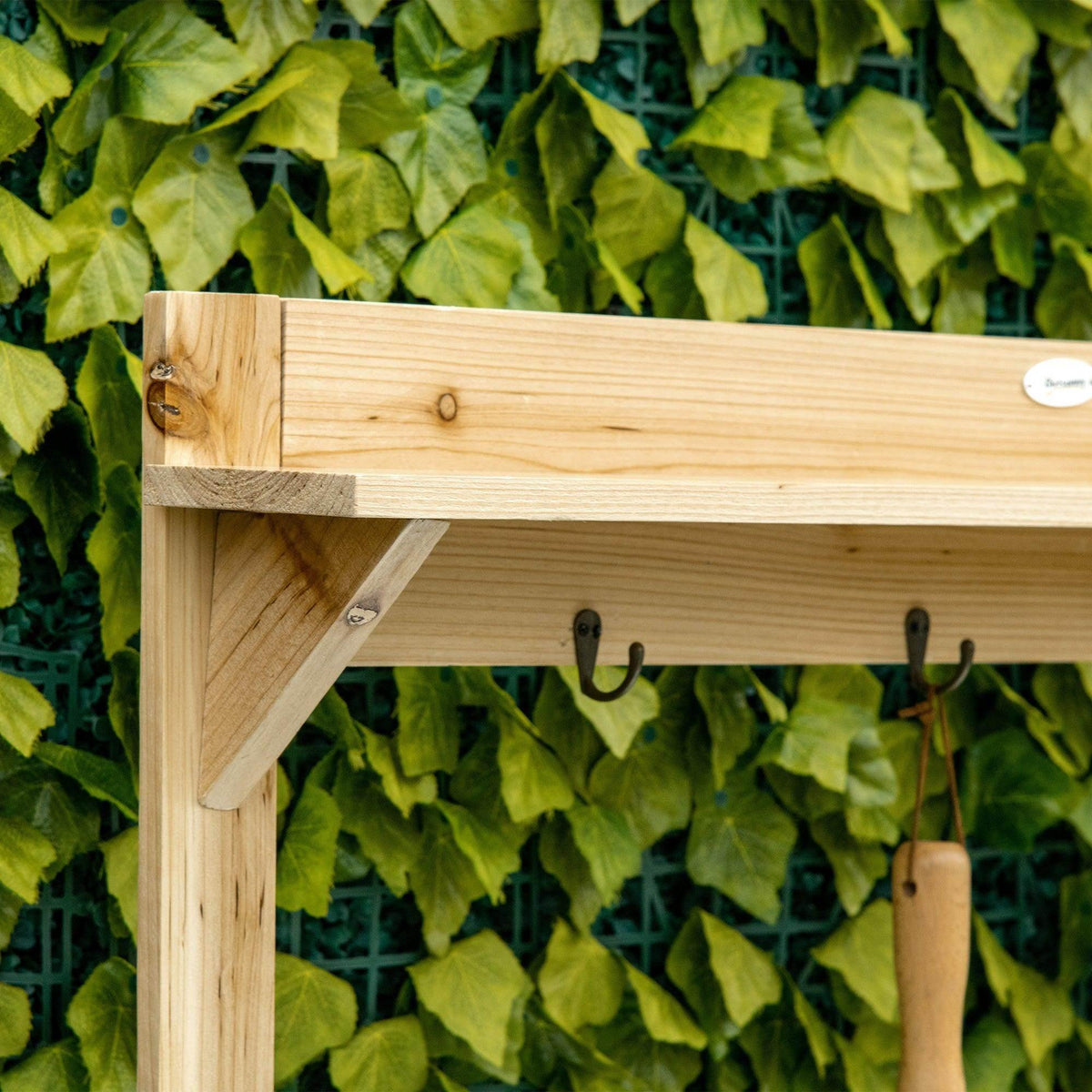 Wooden potting bench corner with angled support and hanging hooks