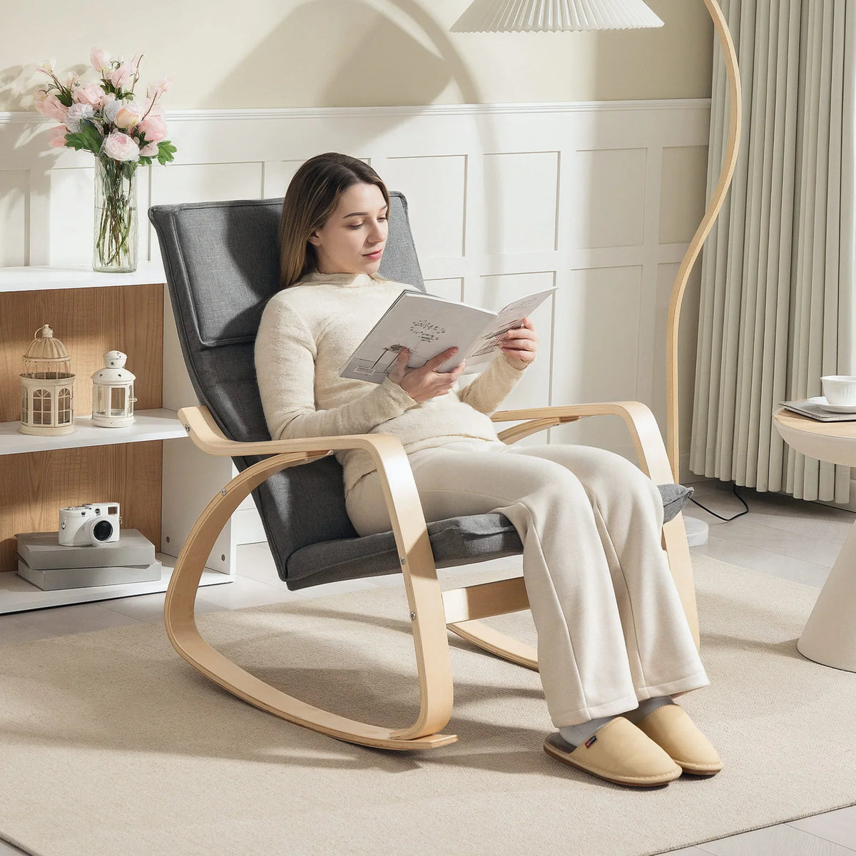 Grey rocking lounge chair with headrest and upholstered back, light wood rocking base