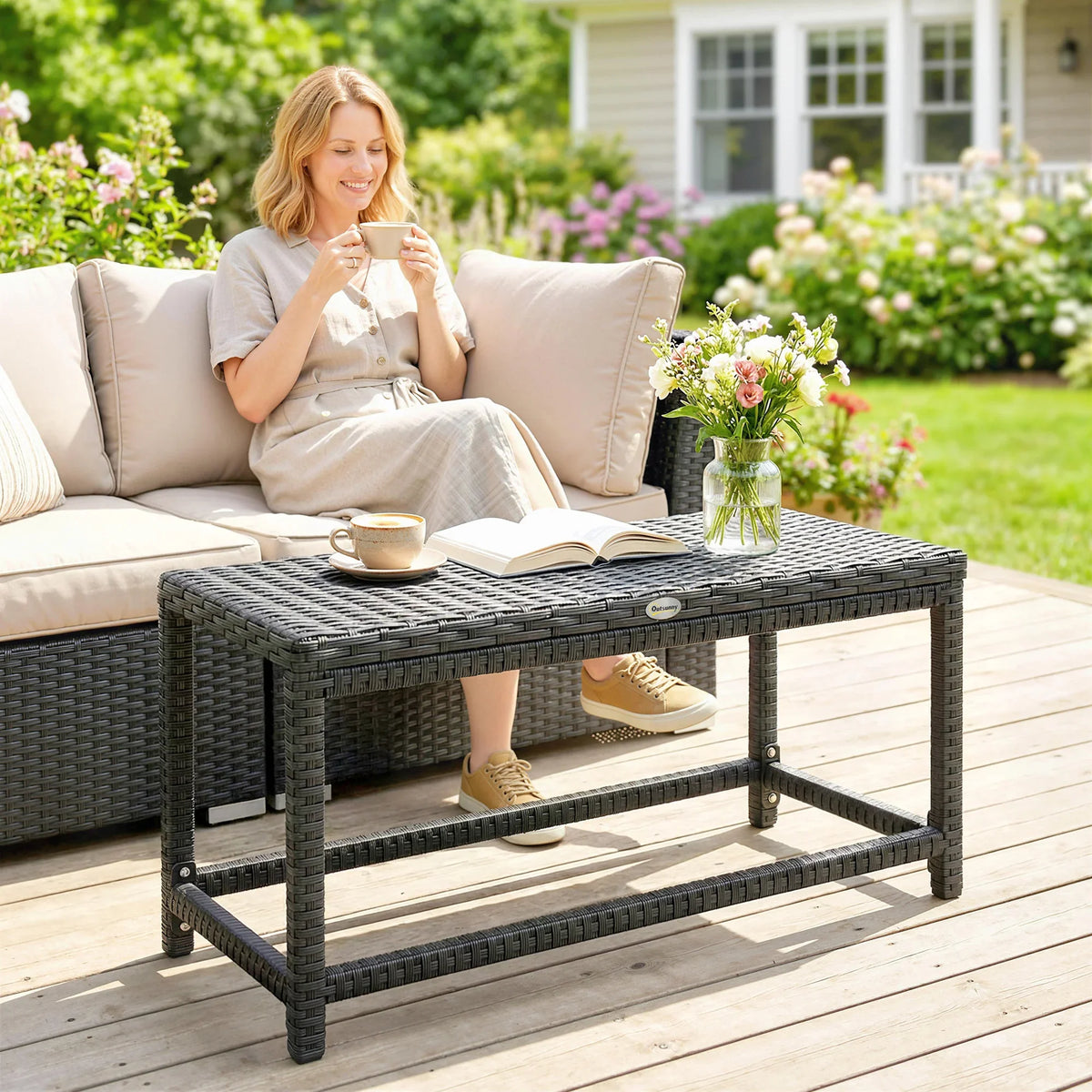 Black rectangular woven outdoor coffee table with lower shelf for patio seating.