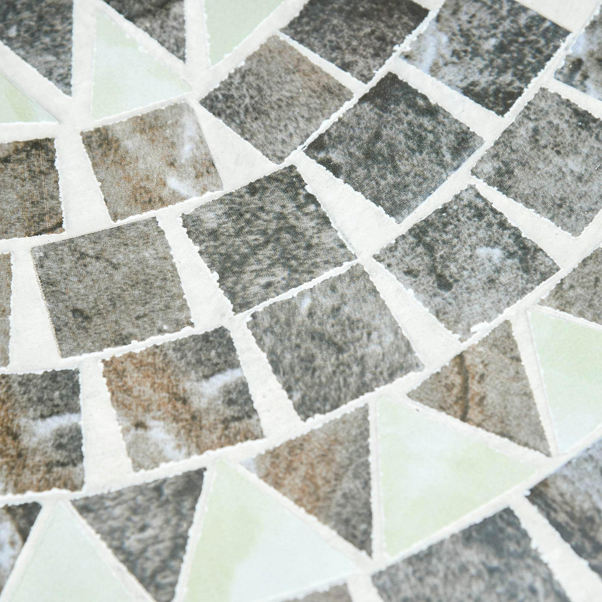 Close-up of grey-and-white mosaic tile surface with geometric pattern