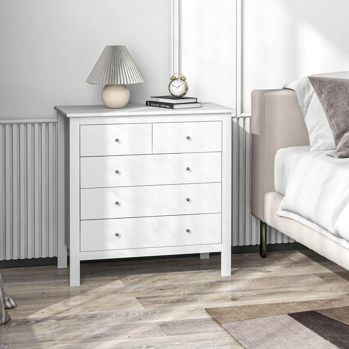 White 5-drawer chest of drawers with metal knobs and flat panel sides.
