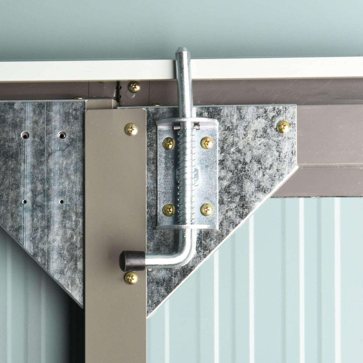 Steel corner brace and hinge bracket on grey metal shed door, with gold fasteners